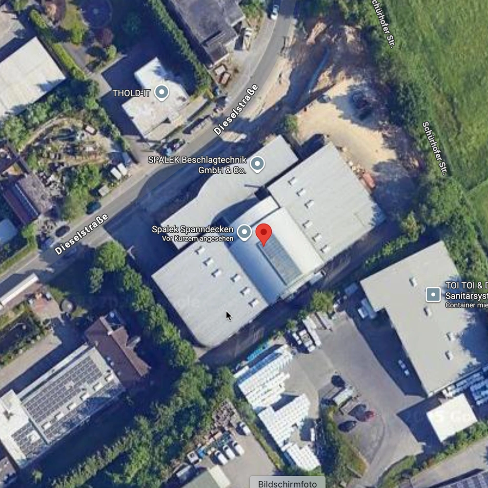 Satellitenansicht eines Industriegebiets mit Hallen, Zufahrten und Grünflächen; Spalek Spanndecken durch Pin markiert.