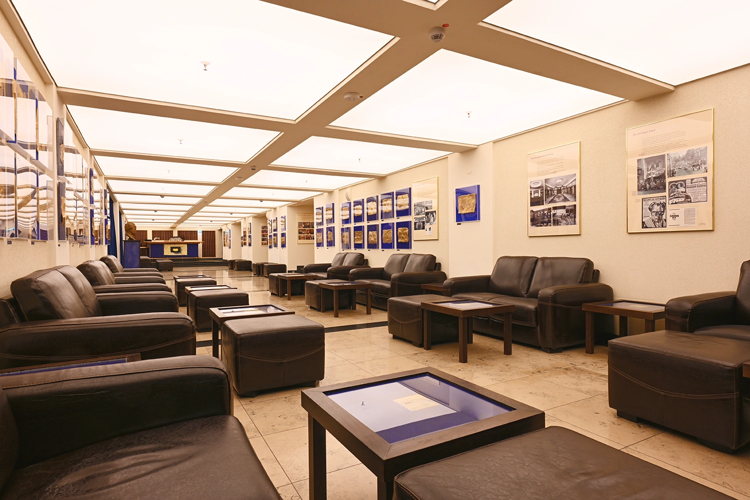 Lichtburg Geräumige, moderne Lounge in der Lichtburg Essen mit schwarzen Ledersofas, niedrigen Tischen und Fliesenboden unter Einbaubeleuchtung.