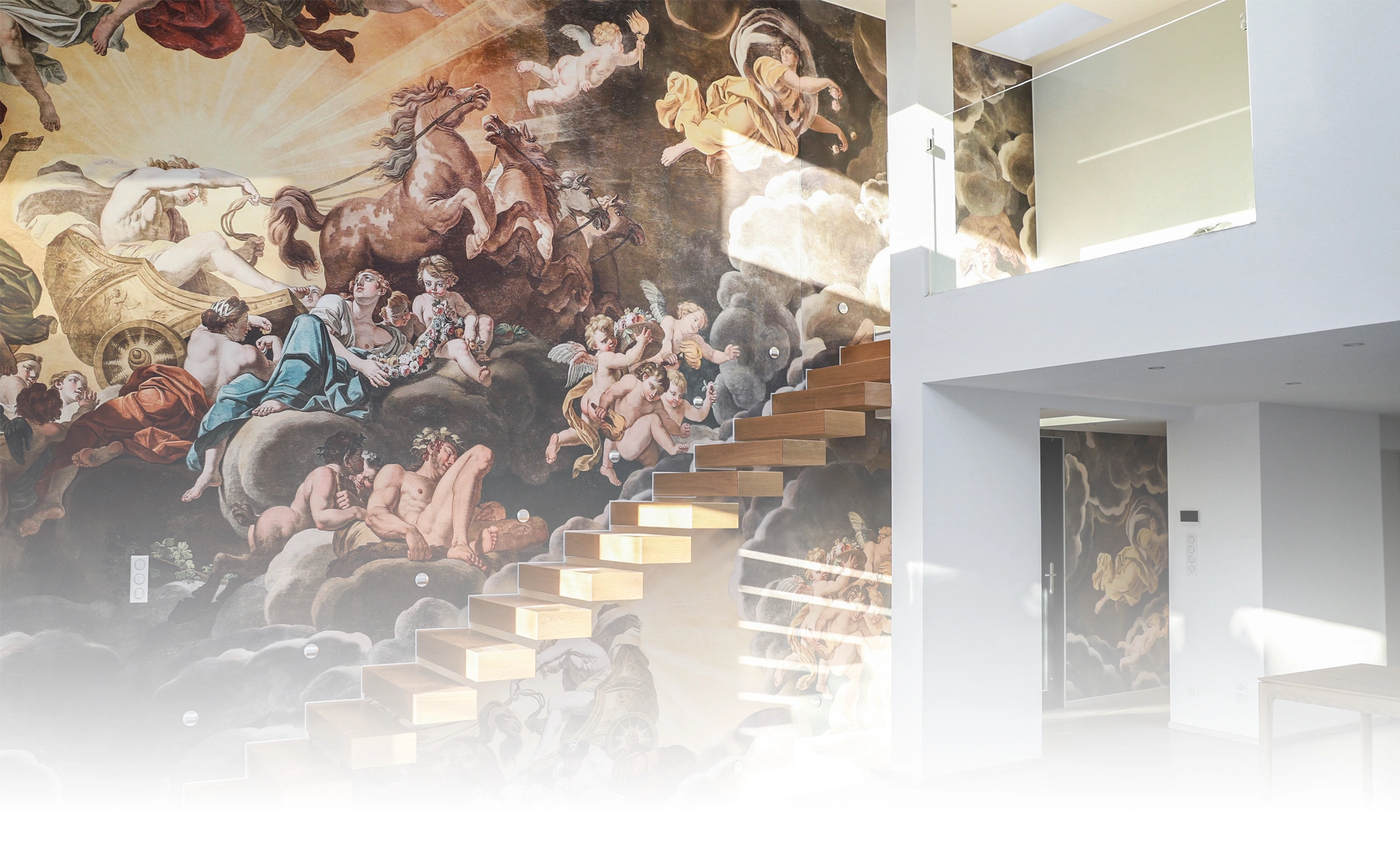 Modernes Interieur mit freitragender Holztreppe, weißen Wänden und einer großen Gewebedecke mit klassischem Wandbild in warmen Tönen.