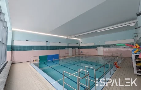 Helles Schwimmbad mit klarem Wasser, Geländern und Fliesenboden, pastellfarbenen Wänden und großen Fenstern im DRK Raisdorf.